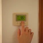 원룸 보일러 조절기에 온돌 모드 또는 낮은 온도를 설정하는 손