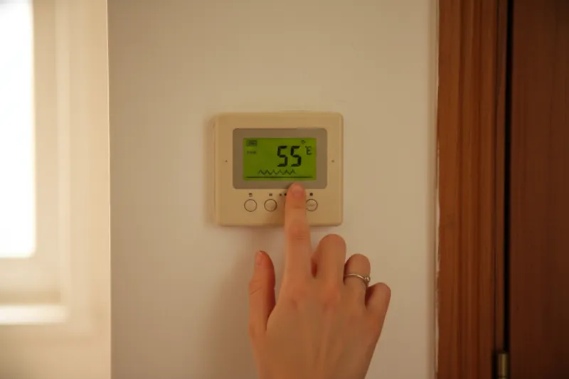 원룸 보일러 조절기에 온돌 모드 또는 낮은 온도를 설정하는 손
