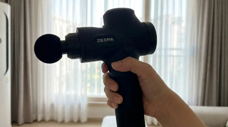 한 손으로 가볍게 쥐고 있는 초경량 미니 마사지건