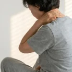 설날 부모님 선물 - 목과 어깨 통증을 느끼며 손으로 주무르는 어머니의 뒷모습