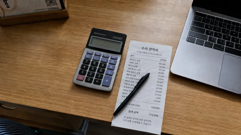 책상 위 계산기와 구겨진 영수증 그리고 볼펜